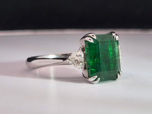 Load image into Gallery viewer, 4.02ct Emerald Cut Green Emerald | 0.47cts [2] Heart Shaped Diamond | Designer Trilogy Ring | 18kt White Gold
